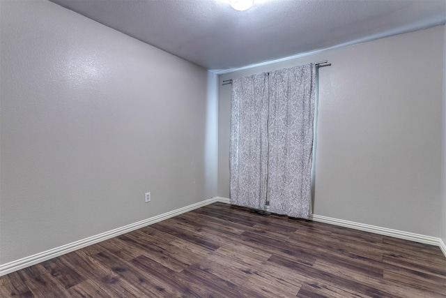 spare room with dark hardwood / wood-style flooring