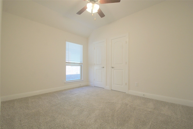 empty room featuring carpet flooring, ceiling fan, and lofted ceiling