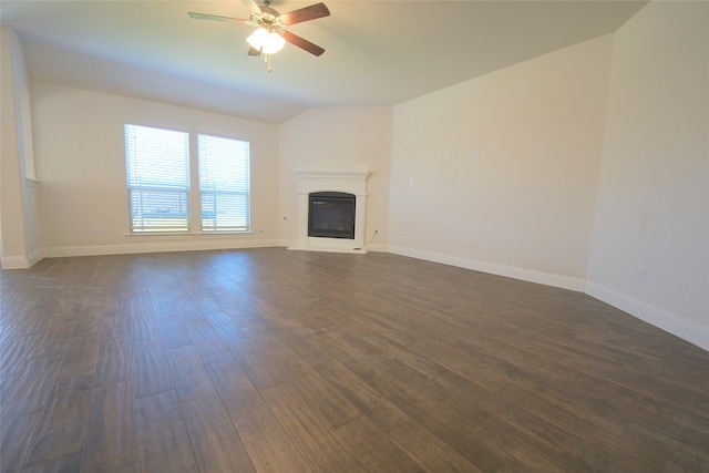 unfurnished living room featuring dark hardwood / wood-style floors, ceiling fan, and vaulted ceiling