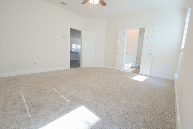 interior space featuring ceiling fan, carpet, and ensuite bathroom