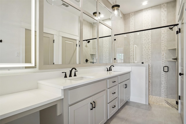 bathroom with a shower with door, vanity, and tile patterned floors