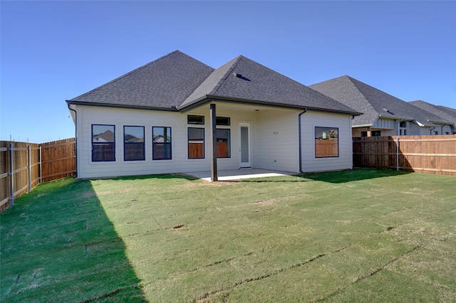 back of property with a yard and a patio area