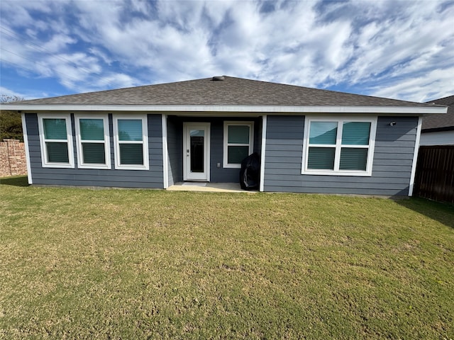 rear view of property featuring a lawn