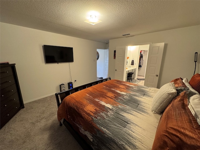 bedroom with carpet, a textured ceiling, and a walk in closet