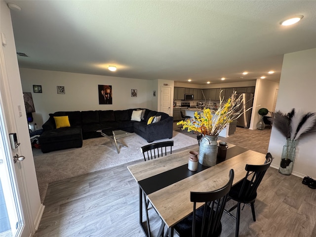 dining area featuring a textured ceiling and light hardwood / wood-style floors