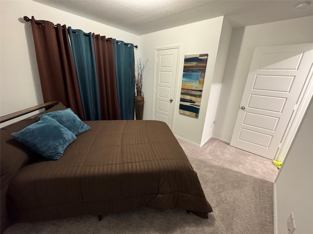 bedroom with a textured ceiling and light carpet