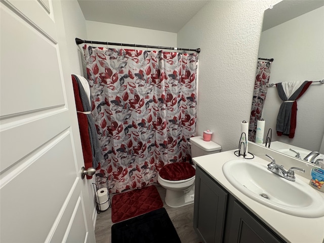 bathroom featuring vanity, a textured ceiling, toilet, and curtained shower