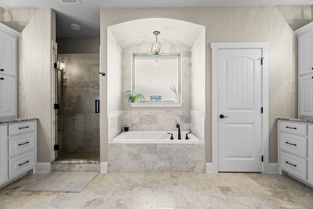 bathroom featuring vanity, an inviting chandelier, and independent shower and bath