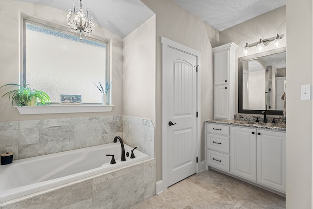 bathroom featuring vanity, a relaxing tiled tub, and a notable chandelier