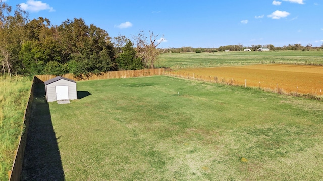 view of yard with a rural view and a storage unit