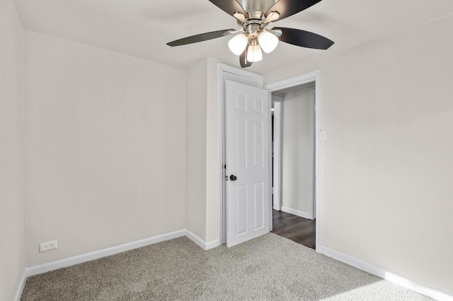 unfurnished room featuring dark colored carpet and ceiling fan