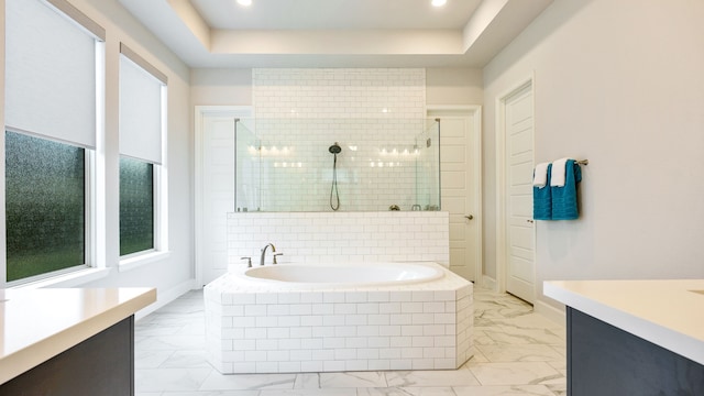 bathroom featuring a tray ceiling, plus walk in shower, and vanity