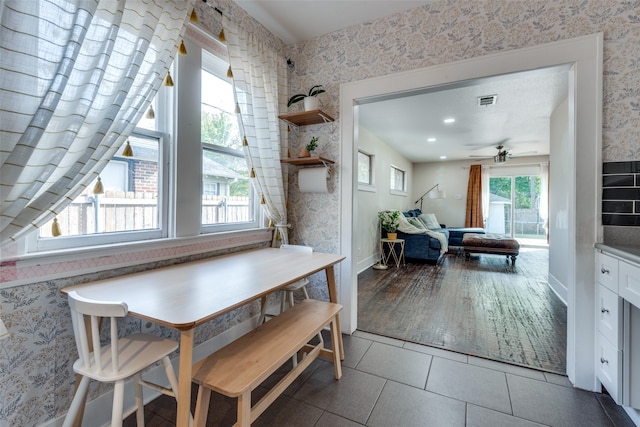 tiled dining space featuring ceiling fan