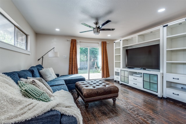 living room with a textured ceiling, dark hardwood / wood-style floors, and ceiling fan