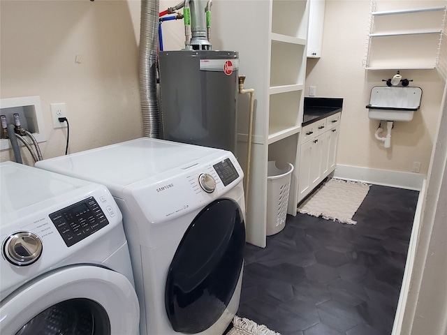 clothes washing area featuring dark tile patterned flooring, independent washer and dryer, and water heater