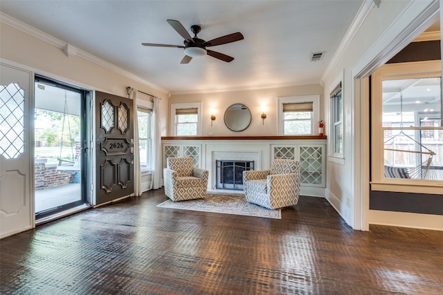 unfurnished living room featuring crown molding, dark wood-type flooring, and ceiling fan