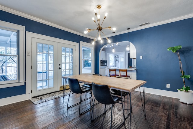 dining area featuring french doors, dark hardwood / wood-style flooring, ornamental molding, and a notable chandelier