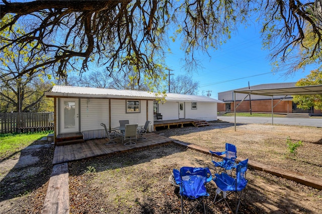 back of house featuring a carport