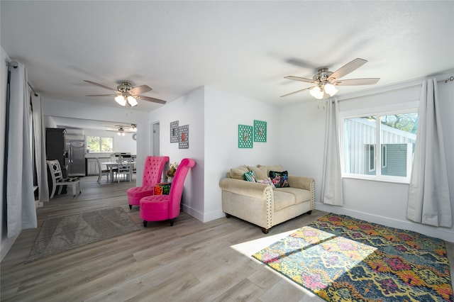 living room featuring ceiling fan and light hardwood / wood-style floors