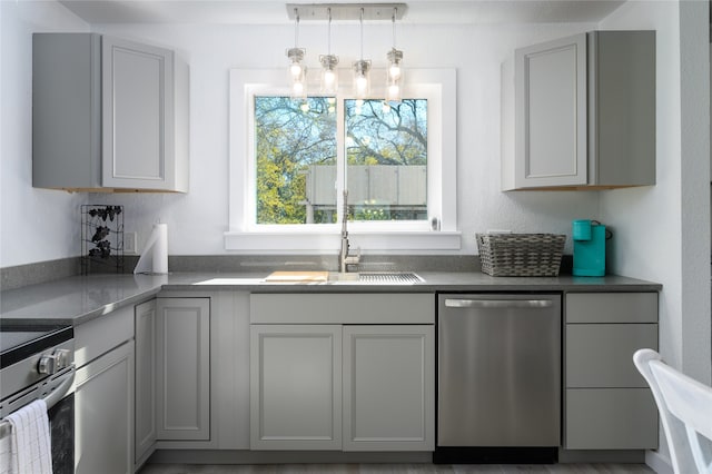 kitchen featuring gray cabinetry, sink, stainless steel appliances, an inviting chandelier, and decorative light fixtures