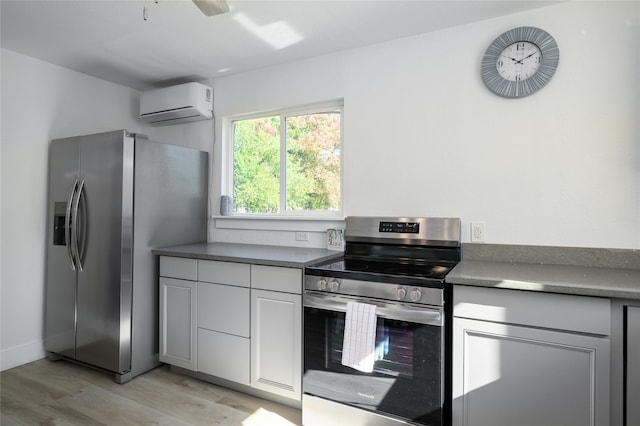 kitchen with ceiling fan, light wood-type flooring, appliances with stainless steel finishes, white cabinetry, and a wall unit AC