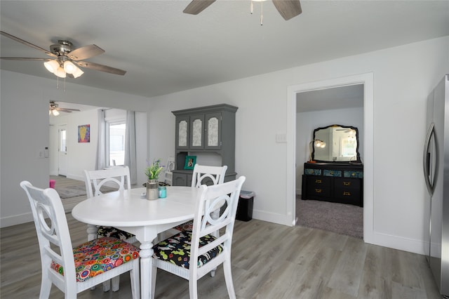 dining space with ceiling fan and hardwood / wood-style floors