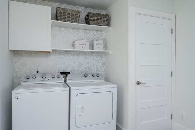 laundry area featuring washer and clothes dryer and cabinets