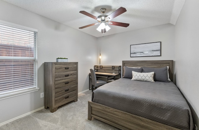 carpeted bedroom with ceiling fan and a textured ceiling