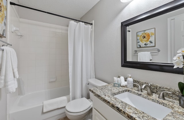 full bathroom with vanity, shower / tub combo, toilet, and a textured ceiling