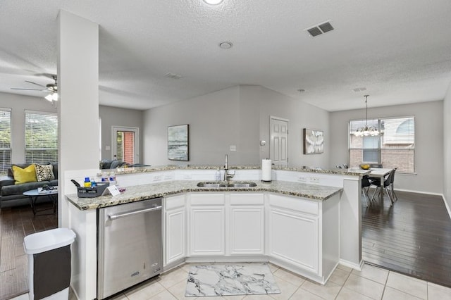 kitchen featuring a wealth of natural light, sink, stainless steel dishwasher, and white cabinets