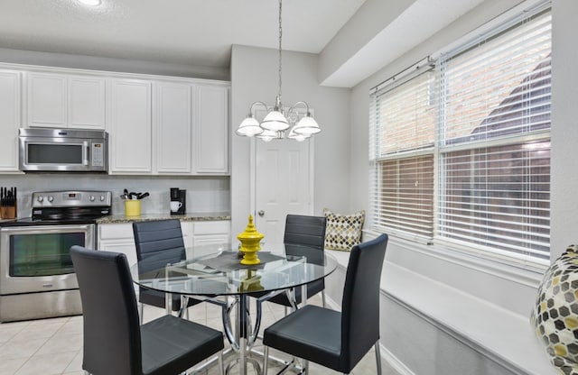 tiled dining area with an inviting chandelier