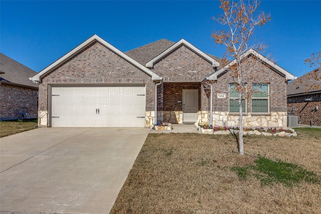 view of front of house featuring central AC, a garage, and a front lawn