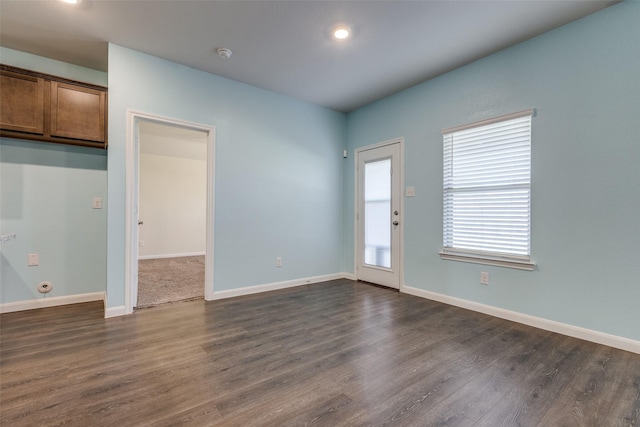 unfurnished room with dark wood-type flooring and a wealth of natural light