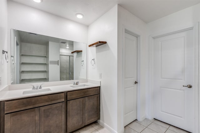 bathroom with tile patterned flooring, vanity, and a shower with door