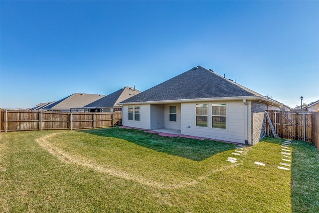 rear view of property featuring a lawn