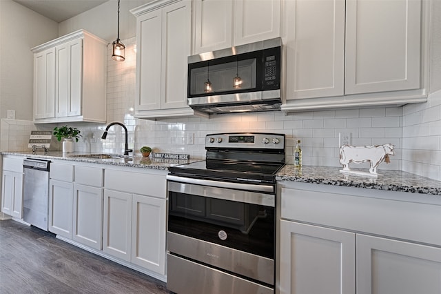 kitchen featuring decorative backsplash, appliances with stainless steel finishes, dark wood-type flooring, sink, and white cabinets