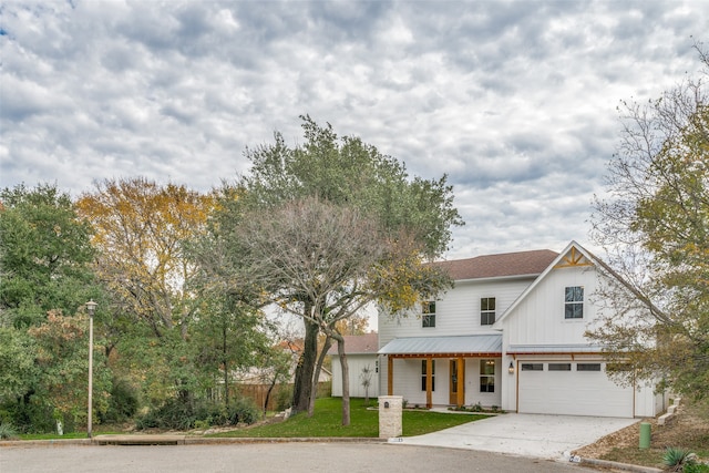 view of front of property featuring covered porch, a front yard, and a garage