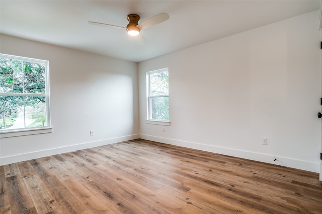 empty room featuring hardwood / wood-style floors, a wealth of natural light, and ceiling fan