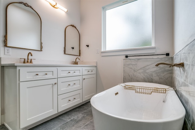 bathroom featuring tile patterned floors, vanity, a bath, and tile walls