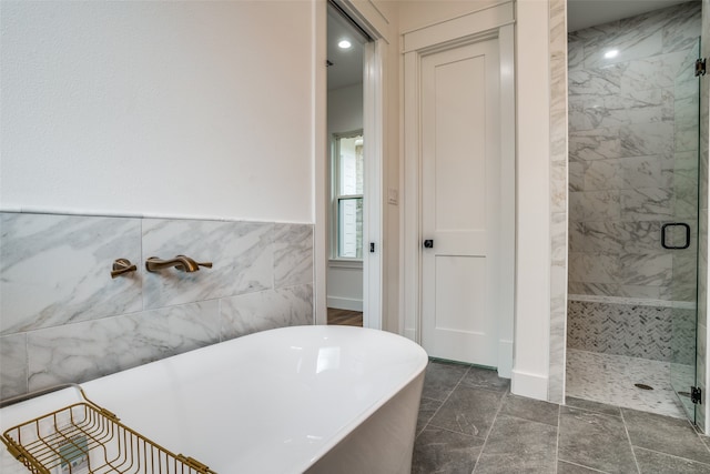 bathroom featuring tile patterned flooring, tile walls, and shower with separate bathtub