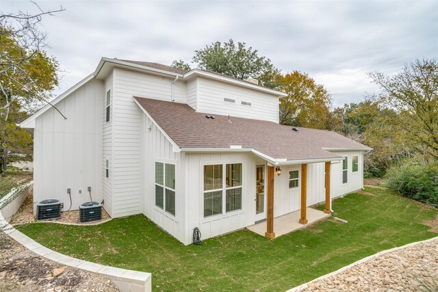 rear view of house with cooling unit, a patio area, and a yard