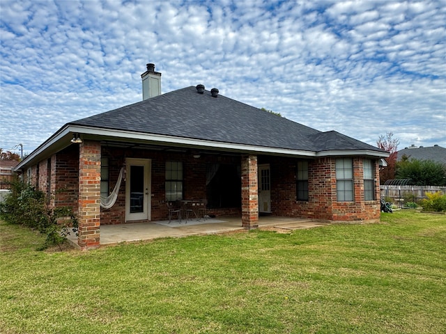 back of property with a lawn and a patio area