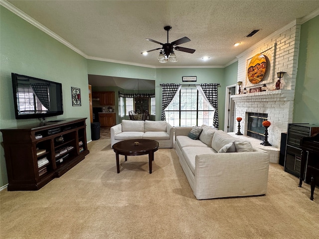 carpeted living room with a textured ceiling, a brick fireplace, ceiling fan, and ornamental molding