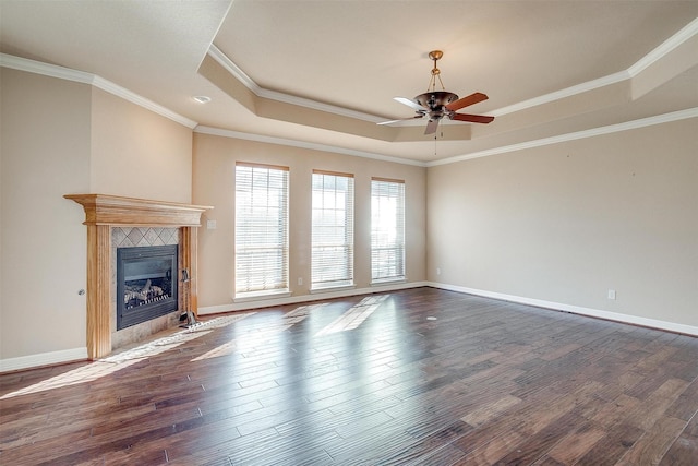 unfurnished living room featuring a fireplace, dark hardwood / wood-style flooring, a raised ceiling, and crown molding