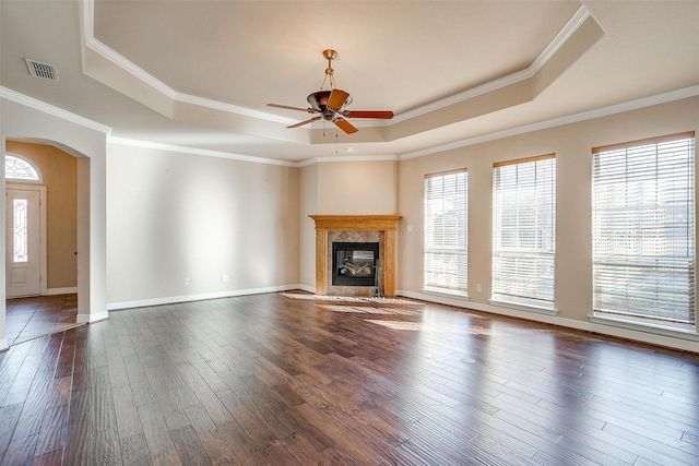 unfurnished living room featuring dark wood-type flooring, crown molding, and a healthy amount of sunlight