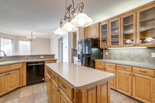 kitchen featuring a notable chandelier, a center island, black appliances, sink, and decorative light fixtures