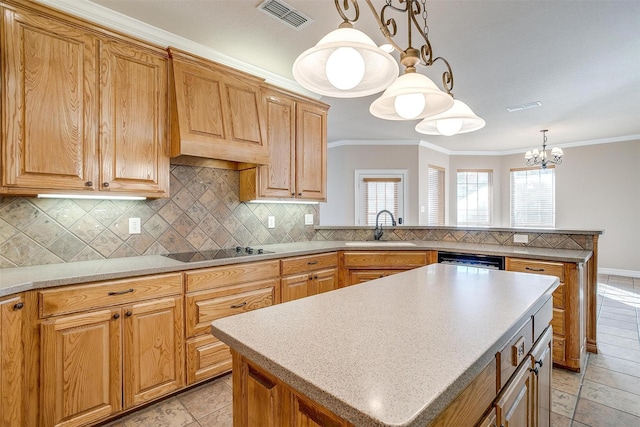 kitchen featuring a center island, sink, decorative light fixtures, black electric cooktop, and a notable chandelier