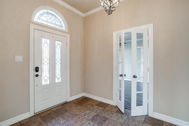 entrance foyer featuring french doors, crown molding, and a chandelier