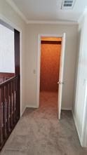 hallway with carpet flooring and crown molding