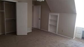 unfurnished bedroom featuring carpet flooring, vaulted ceiling, and a closet